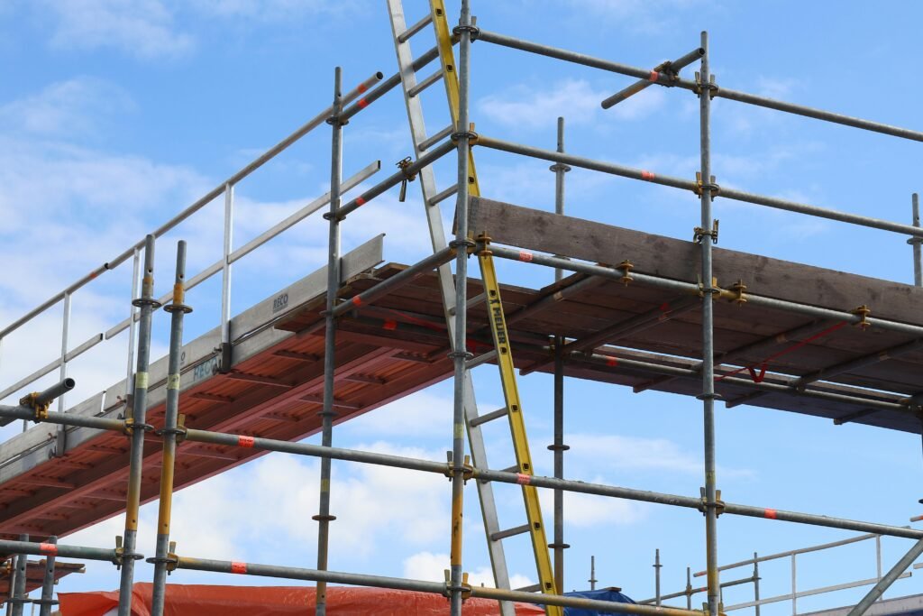 Detailed view of a construction site scaffolding structure and ladder against a bright blue sky.